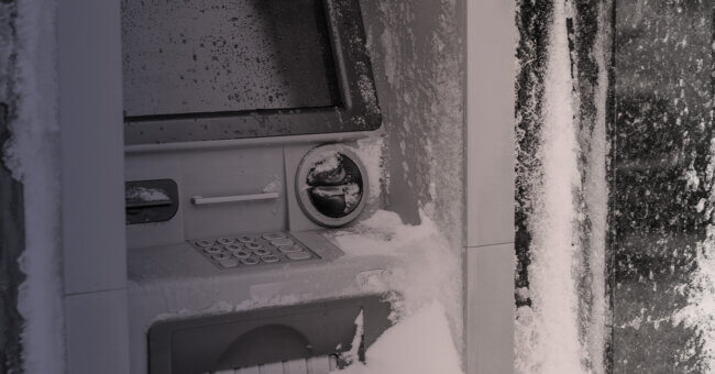 Frozen outdoor ATM covered in ice and snow