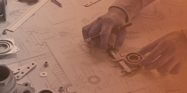 Hands working on mechanical engineering drawings with tools and parts.